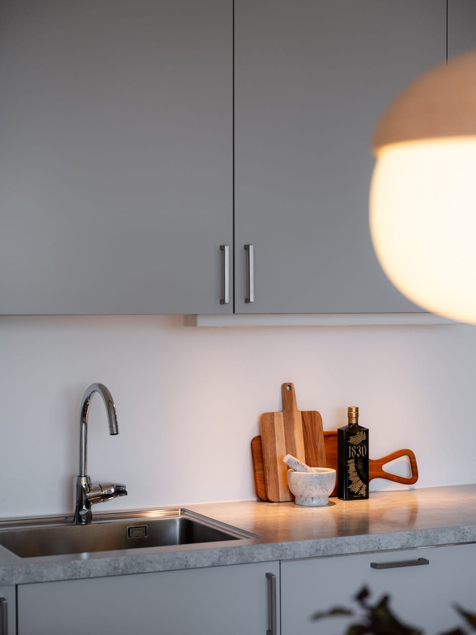 Innredningen har grå glatte fronter og laminert benkeplate med underlimt oppvaskkum.
