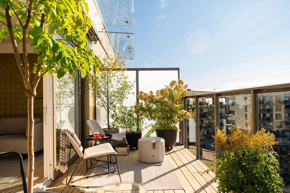 Balkongen har terrassebord på gulv, levegger med frostet glass og rekkverk med glassfelt i front.