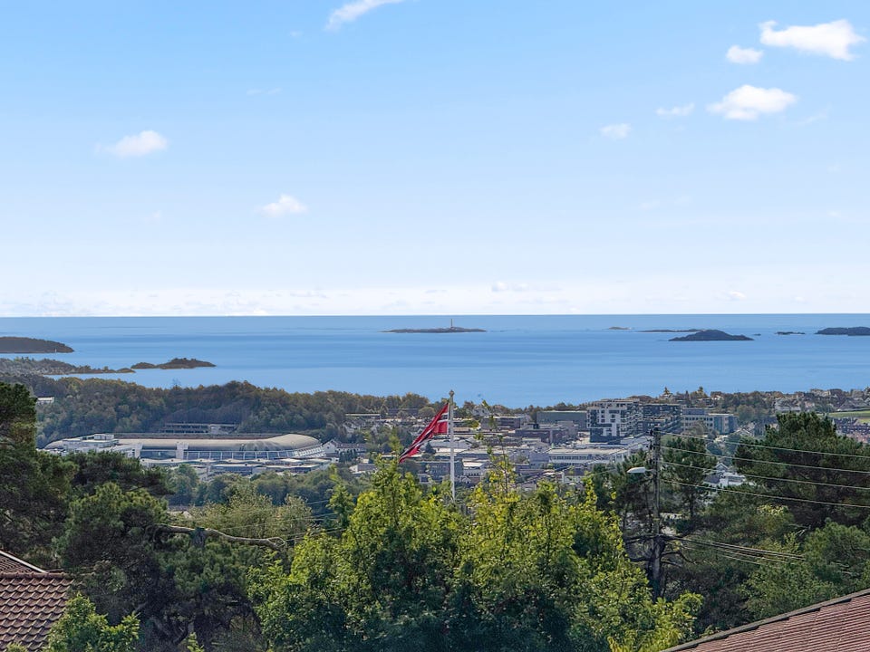Lys og åpen utsikt fra stuen med panoramablikk over byen, sjøen og holmene utenfor.