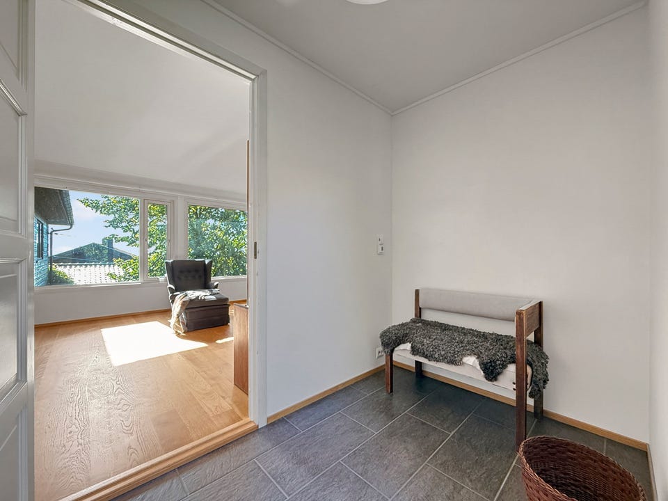 Lys entré med flislagt gulv og romslig skyvedørsgarderobe.