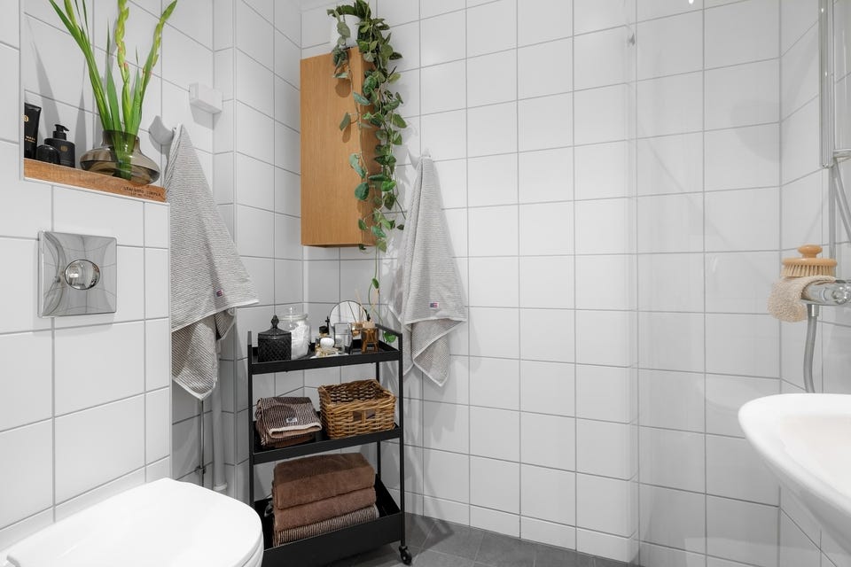 Baderommet er også utstyrt med ekstra vegghengt skap, dusjhjørne med innfellbare glassdører og vegghengt toalett.