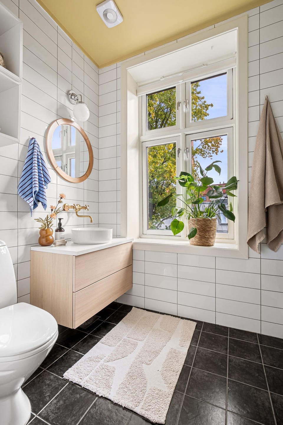 Badet er flislagt og innredet med servant, dusjkabinett, toalett og opplegg for vaskemaskin. Rommet har gulvvarme og mekanisk avtrekk.