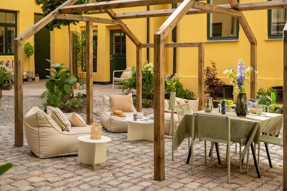 Felles pergola med plass til sittegruppe. Møblene på bildet er styling; leiligheten har ikke privat markterrasse.