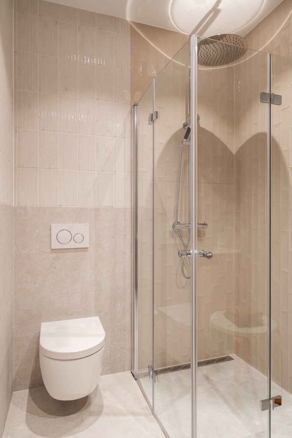 Badet har dusjhjørne med leddede glassdører, takdusj fra VikingBad og vegghengt toalett.