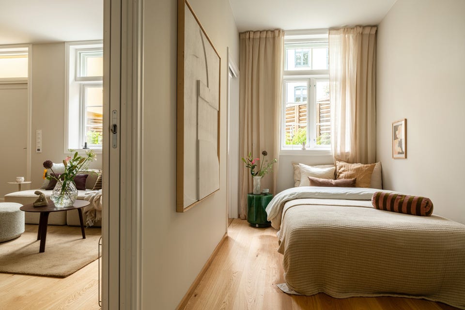 Soverommet ligger innenfor stuen, med vindu mot indre gård og plass til seng langs veggen.
