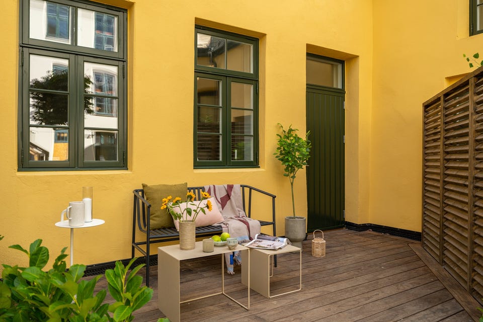 Terrassen ligger langs boligens vinduer, med egen inngang og beplantning som rammer inn uteplassen.