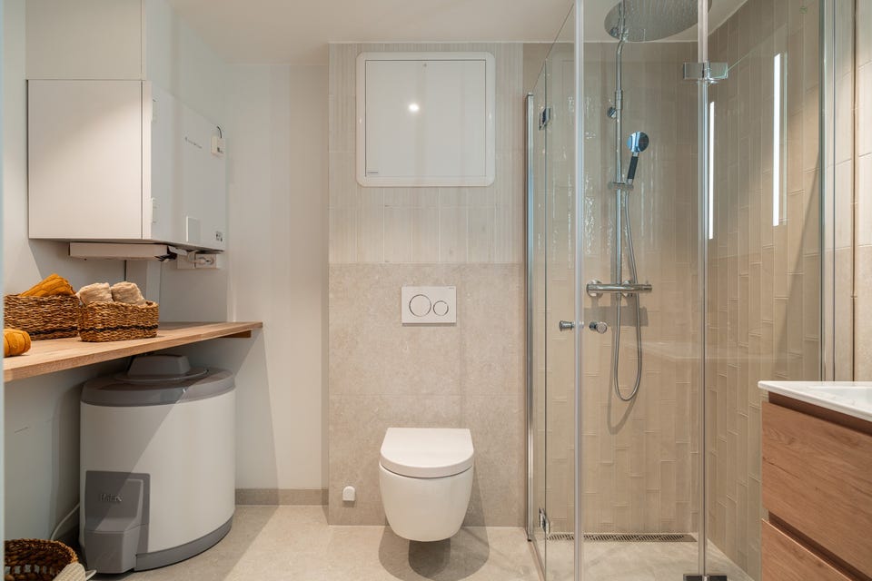 Flislagt bad med gulvvarme, dusjhjørne og vegghengt toalett. Badet er etablert ved ombyggingen i 2026.