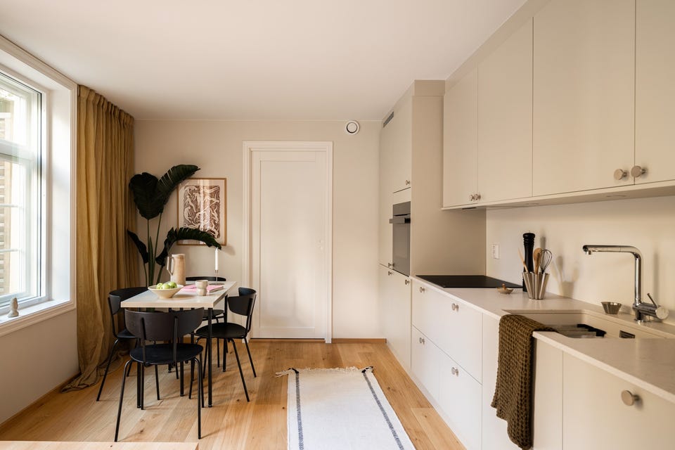 Spiseplassen ligger ved kjøkkenvinduet, med benkeplassen like ved og tydelig forbindelse til resten av leiligheten.