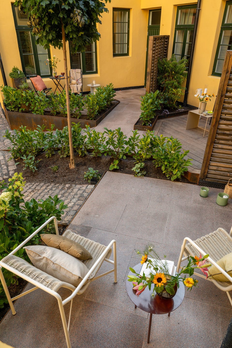 Terrassen sett ovenfra viser forholdet mellom sitteplassen, beplantningen og boligens egen inngang.