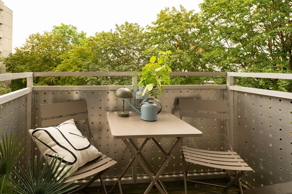Balkongen er overbygget, har terrassebord på gulv og plass til et koselig kafé-sett.