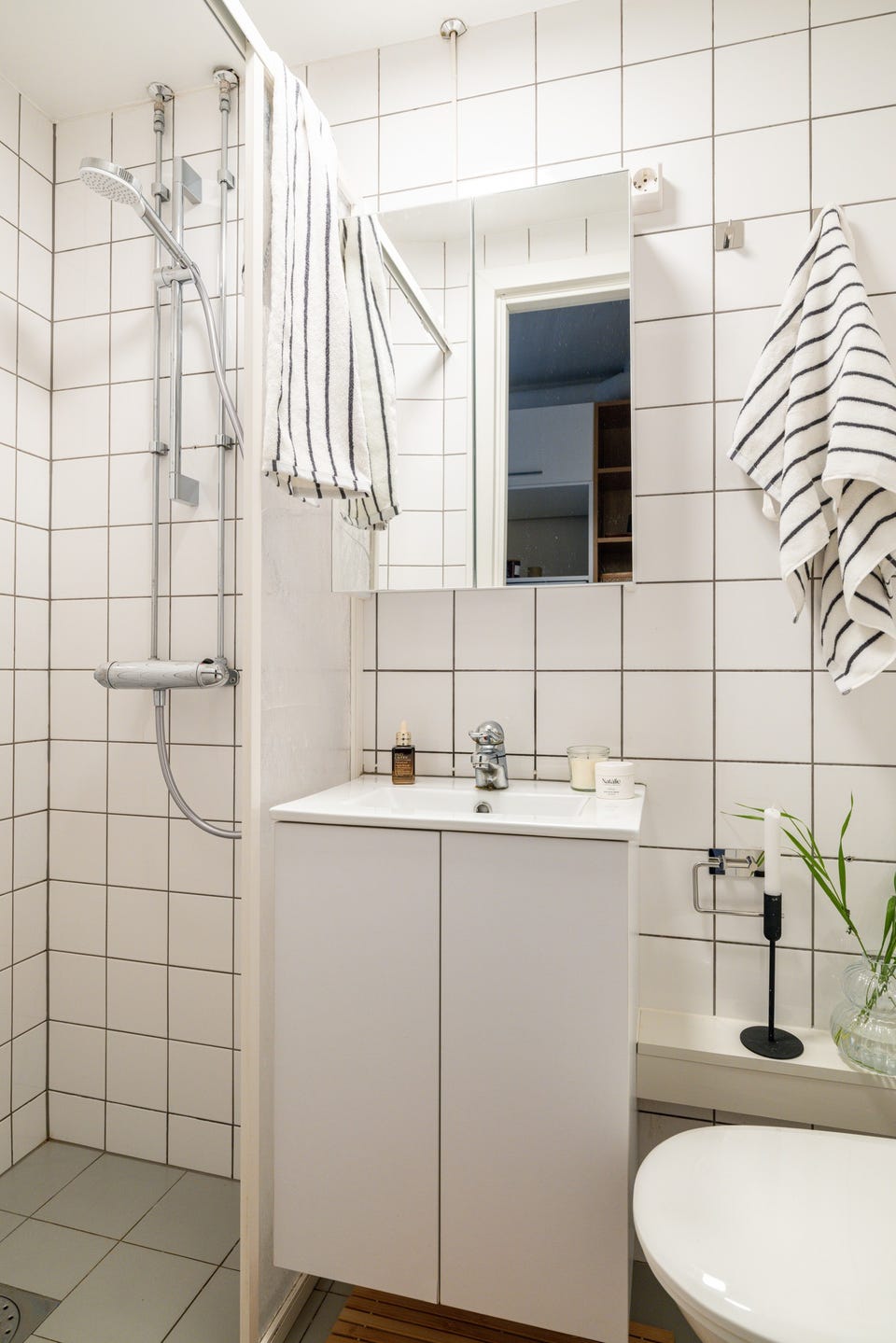 Baderommet er utstyrt med lyst servantskap med speilskap over, dusjnisje med delevegg og vegghengt toalett.
