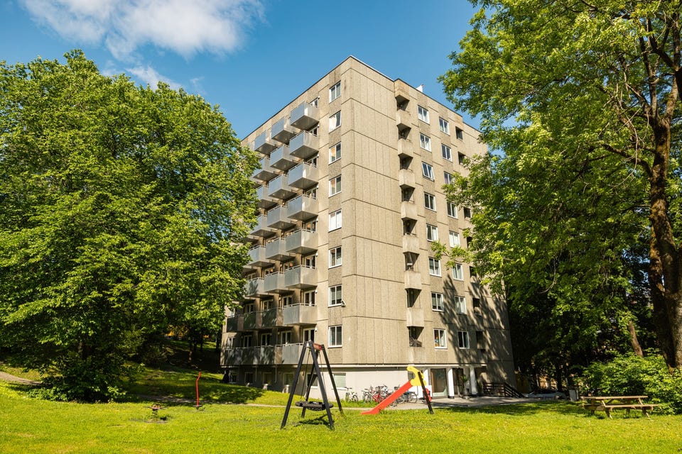 Fasaden sett fra det grønne fellesarealet ved bygningen.