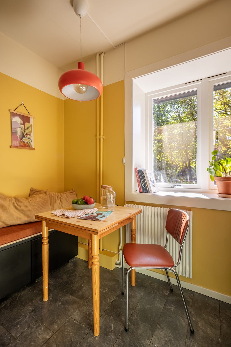 Ved vinduet er det en koselig spiseplass med utsyn mot den grønne og velstelte felleshagen, et perfekt sted å starte dagen med morgenkaffen.