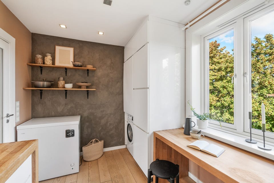 Det er nedsenket himling med downlights og gulvflate belagt med parkett.