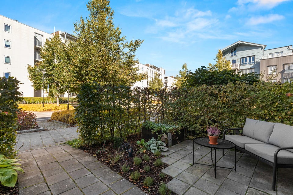 Det er hellebelagt gangparti med plantekasser, beplantning og hekk.
