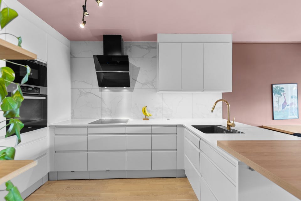 Innredningen har hvite glatte fronter og laminert benkeplate med planlimt oppvaskkum og messing armatur med uttrekkbar tut. Kjøkkenet har også praktiske sokkelskuffer!