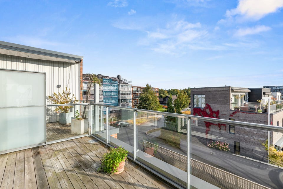 Takterrassen har terrassebord på gulv, moderne glassrekkverk, elektrisk markise, utebelysning og utvendig stikkontakt.