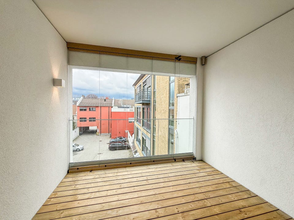 Romslig innglasset balkong mot bakgården - glassene kan skyves til side. Bilde fra en annen lik leilighet