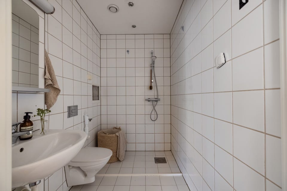 Et lyst flislagt baderom fra 2011 med vannbåren gulvvarme, downlights i himlingen og avtrekk via balansert ventilasjon.