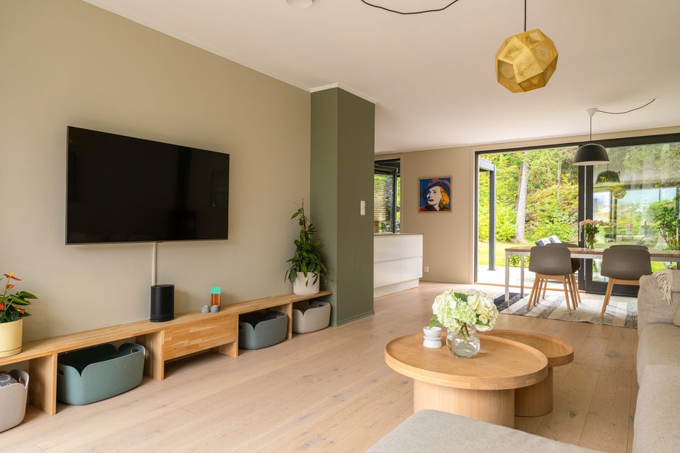 Stuen er romslig med god plass til sofagruppe med salongbord, mediemøbelement med tv og et stort spisebord i tilknytning til kjøkkenet.