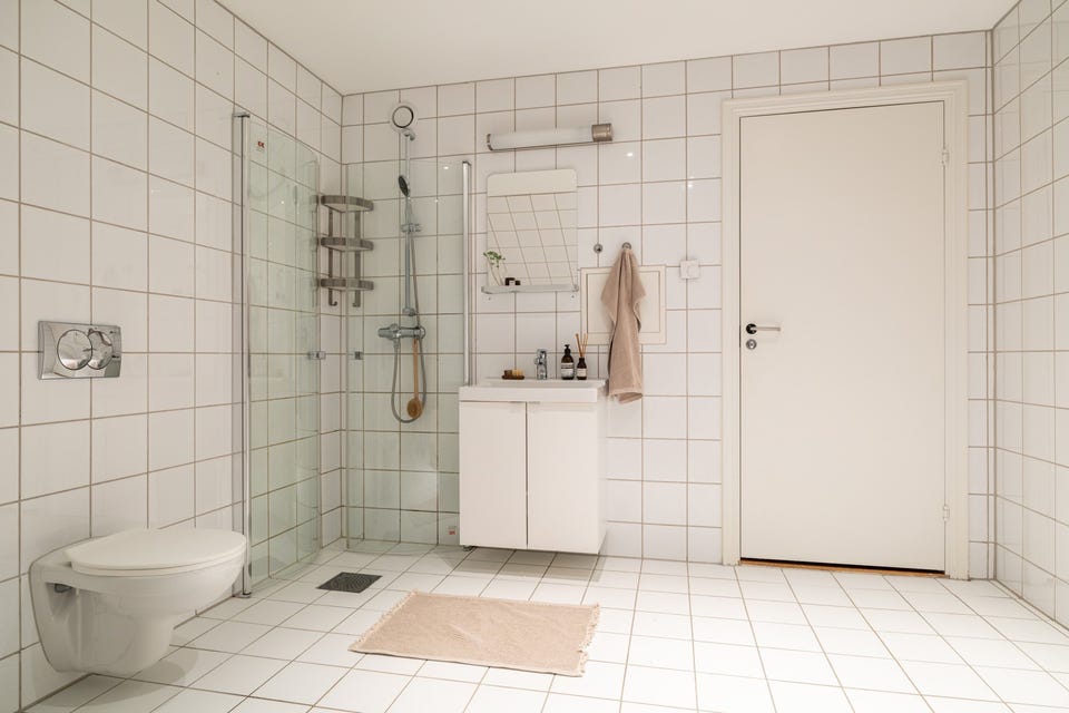 Baderommet er også utstyrt med dusjhjørne med innfellbare glassdører og vegghengt toalett.