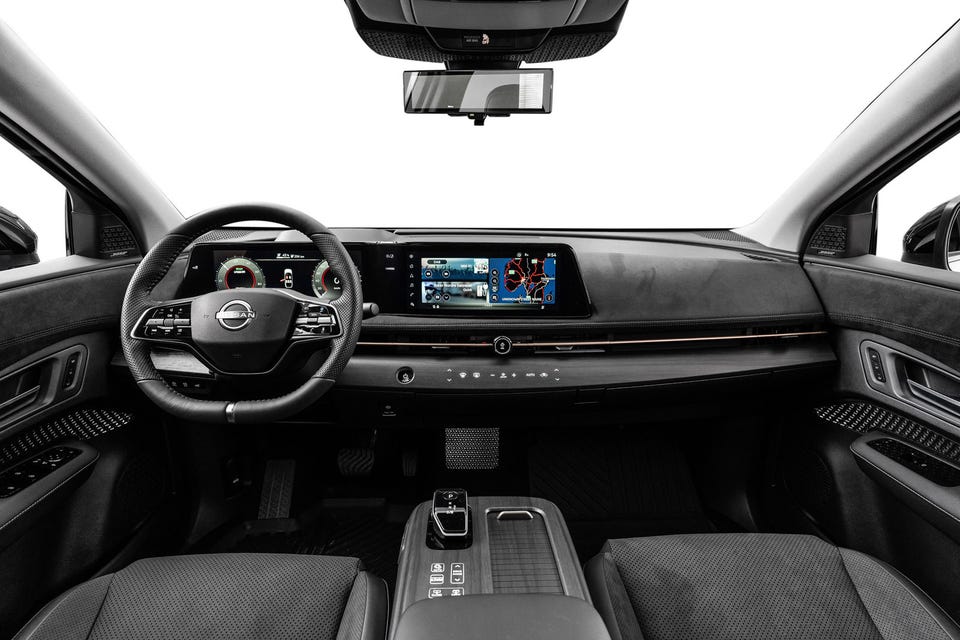 Moderne interiør med doble skjermer, minimalistisk dashbord og premium materialer