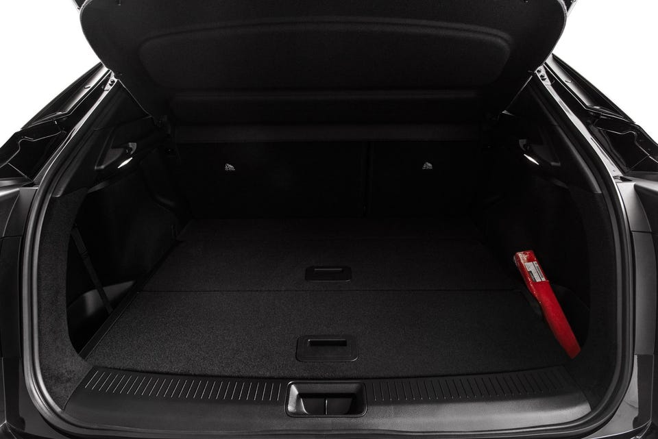 Romslig bagasjerom med mørk teppebelegg og praktiske skjulte oppbevaringsrom i gulvet