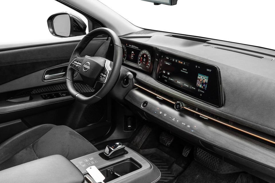 Dobbelt widescreen-display, ambient lys i gull/kobber, perforert sportsratt og minimalistisk dashbord i mørke materialer