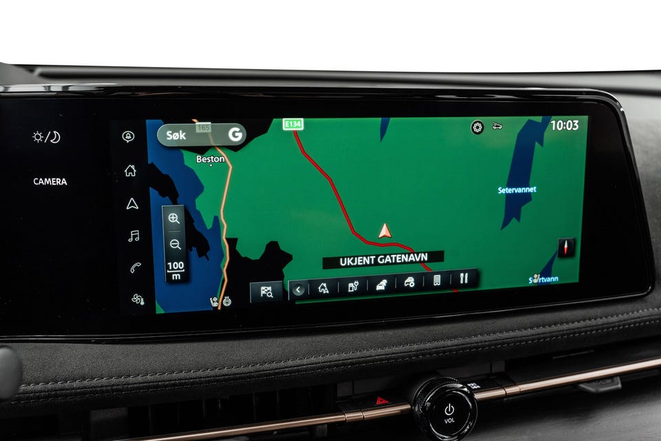 Bred infotainmentskjerm med integrert navigasjon og mørkt dashbord med premium detaljer