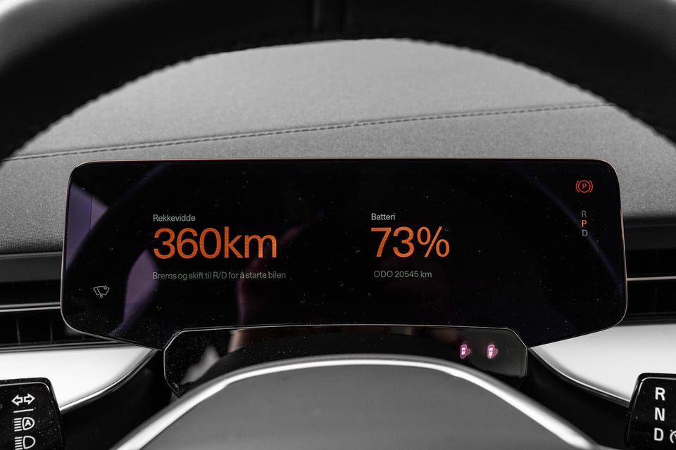 Digitalt instrumentpanel med oransje display, minimalistisk design og premium detaljer