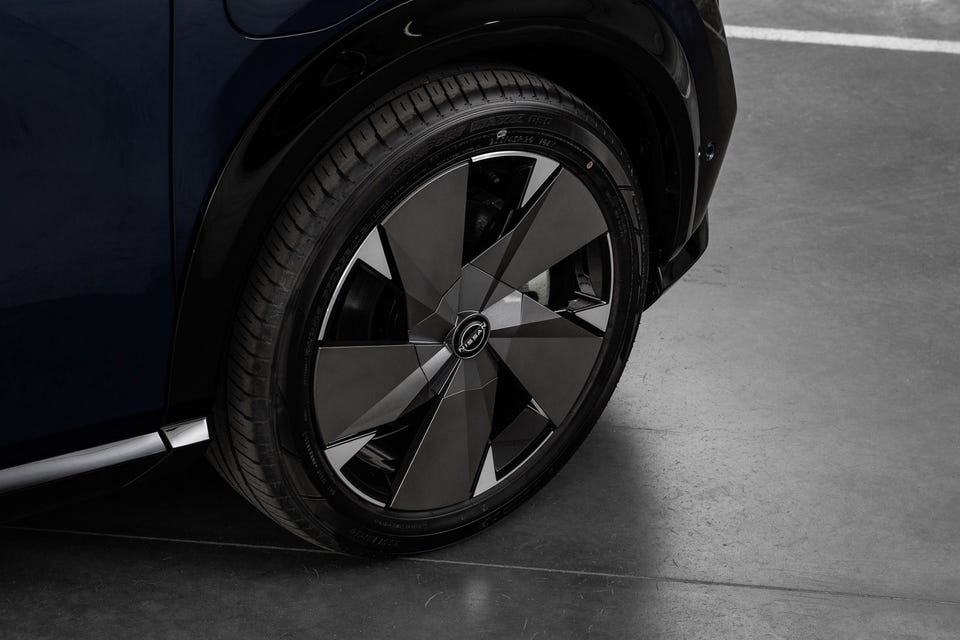 Aerodynamiske svarte felger med geometrisk bladdesign og Nissan-logo i sentrum