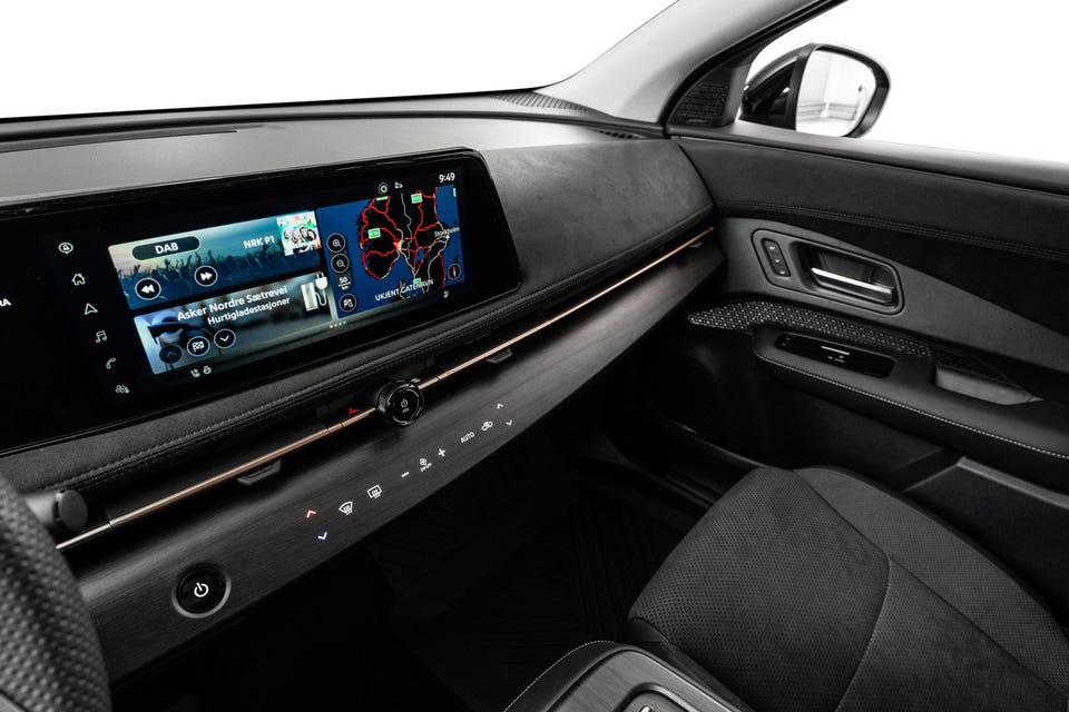 Bred infotainmentskjerm, alcantara-lignende dashbord, kobberfargede detaljer og minimalistisk kontrollpanel