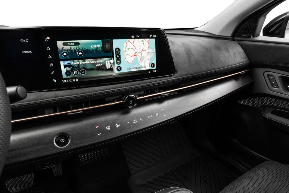 Bred infotainmentskjerm, minimalistisk dashbord med alcantara-finish og kobberfarget detaljestripe