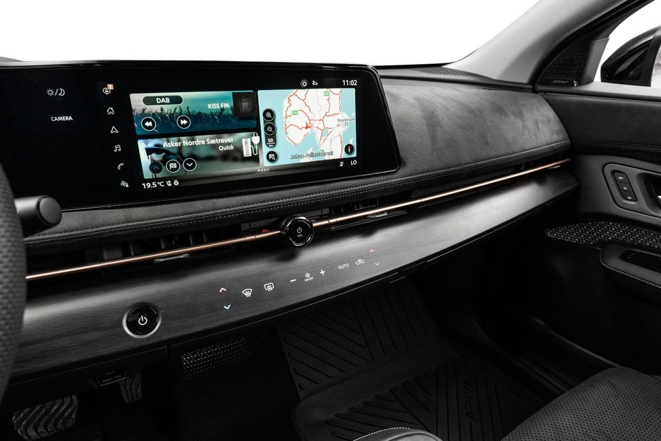 Bred infotainmentskjerm, minimalistisk dashbord i alcantara-lignende materiale, kobberfarget detaljestripe