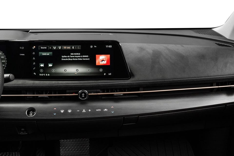 Bred infotainmentskjerm, alcantara-lignende dashbord, kobberfargede detaljer og minimalistisk kontrollpanel