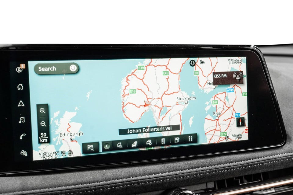 Bred infotainmentskjerm med integrert navigasjon og premium dashborddetaljer med sømdetaljer i alcantara