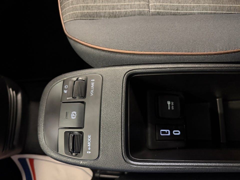 Stoffseter med oransje kantdetaljer, e-MODE-knapp og elektronisk parkeringsbrems, USB-tilkoblinger