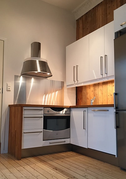 Hvite skap med kjøkkenbenk i eik.