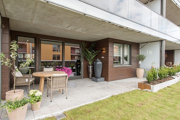 Leiligheten har stor overbygget terrasse med koselig utemiljø