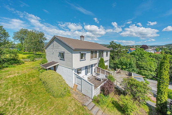 Boligen ligger på et høydedrag med stor hage og fine solforhold.