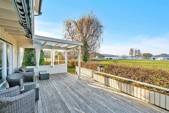 Solrik og delvis overbygget terrasse med nedgang til hage. Sol fra tidlig morgen til kveld.