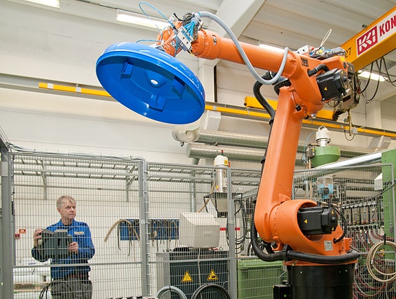 Bilder av en 6-akset robot som er synkronisert med plastmaskinen
