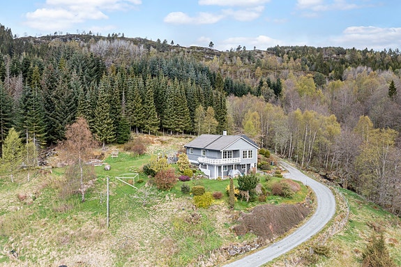 Velkommen til Holmedalsvegen 271 og 309! Eiendommen i bildet er Holmedalsvegen 309 og er en innholdsrik enebolig med pent opparbeidet tomt.