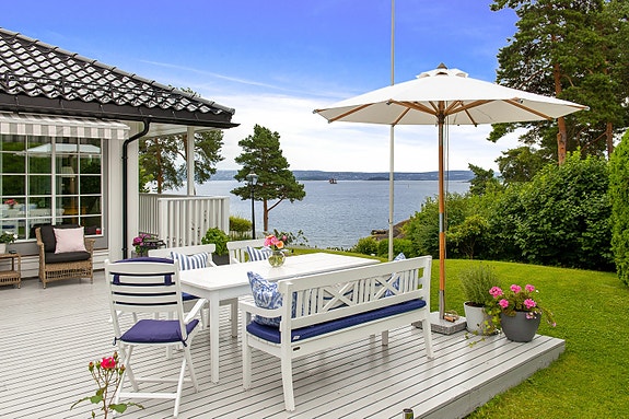 Utgang fra stuen til herlig terrasse og hage samt strandparsellen - Fantastisk, skiftende utsikt med båtliv mm