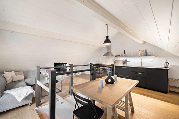 Stuen/kjøkkenet har plass til spisebord og sofa på hver side av trappeløpet