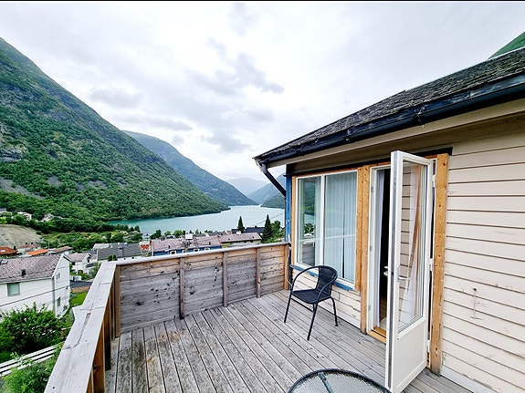 Leiligheten har en balkong utenfor stuen med flott utsikt over bygd, fjell, fjord og Årdalsvatnet.