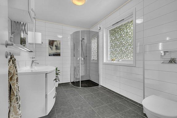 Bad med dusjhjørne, fliser på gulv og baderomsplater på vegg!