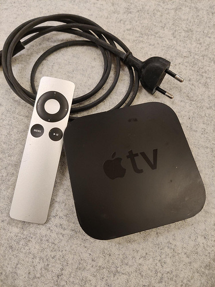 Apple tv med fjernkontroll og strømledning.