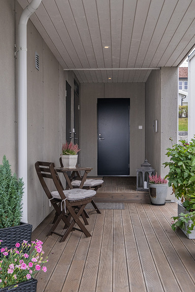 Overbygd inngangsparti gir skjerming for være og vind. Foto fra bolig i andre byggetrinn. Også boligene på det nye byggetrinnet vil ha overbygd terrasse.