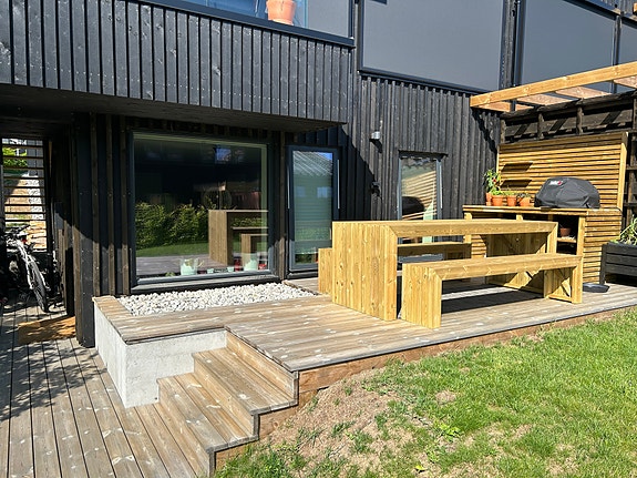 Egen inngang og fint uteområde med platting og tilgang til spiseplass og grill.